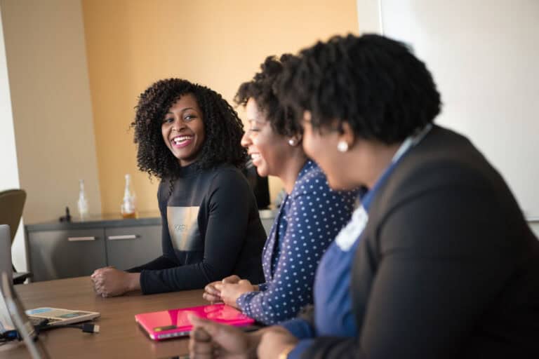 Empowered women sharing mentorship experiences at a holiday event.