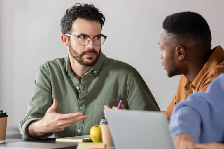Two men engaged in a mentoring session, discussing educational strategies.