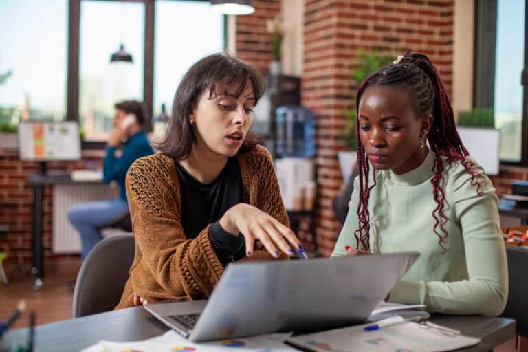 Mentoring in education: teacher and student collaborating on a laptop.