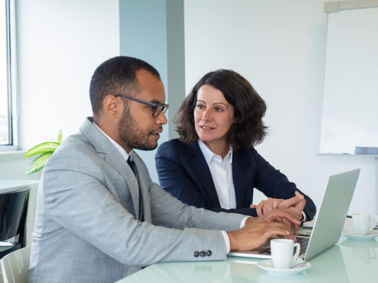 Two professionals engaged in a mentoring session in a nonprofit setting.