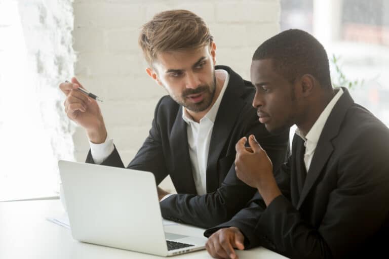 Two managers discussing mentoring strategies for new hire onboarding.