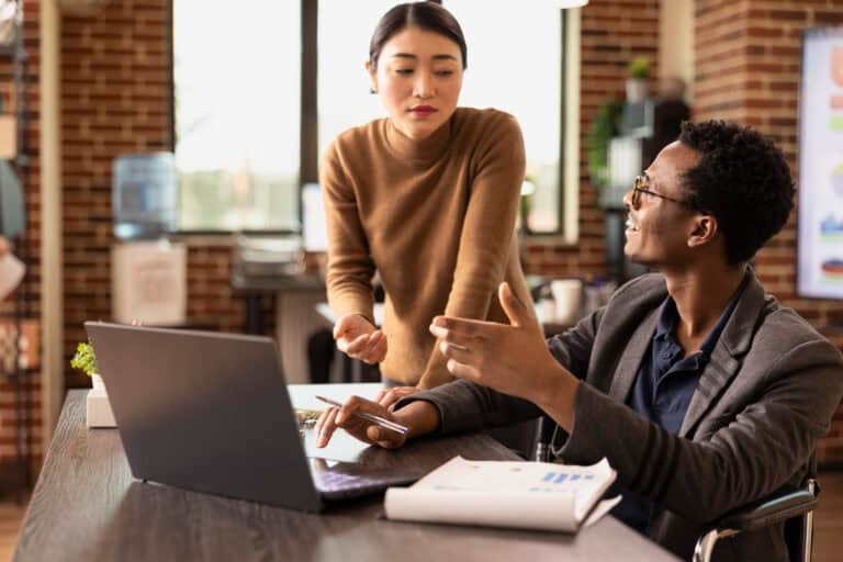 Mentor and mentee engaging in a professional discussion at a desk.