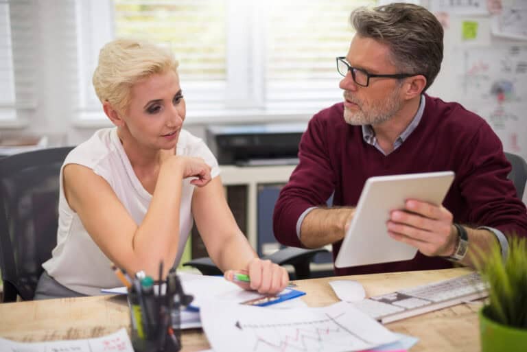 Business mentors discussing financial mentoring strategies at a desk.