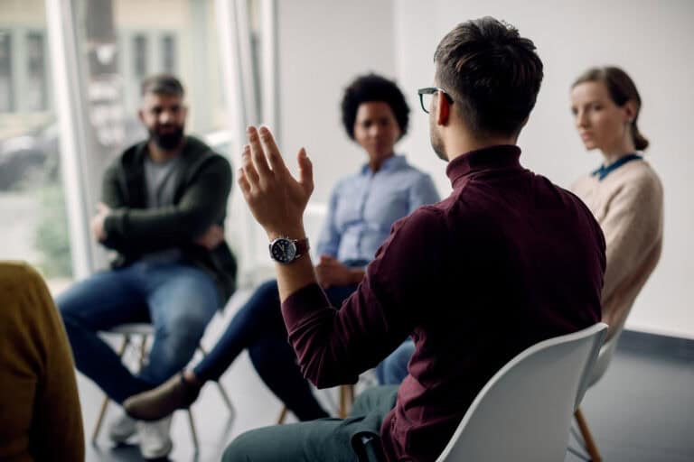 Group of diverse professionals engaging in a mentorship discussion indoors.
