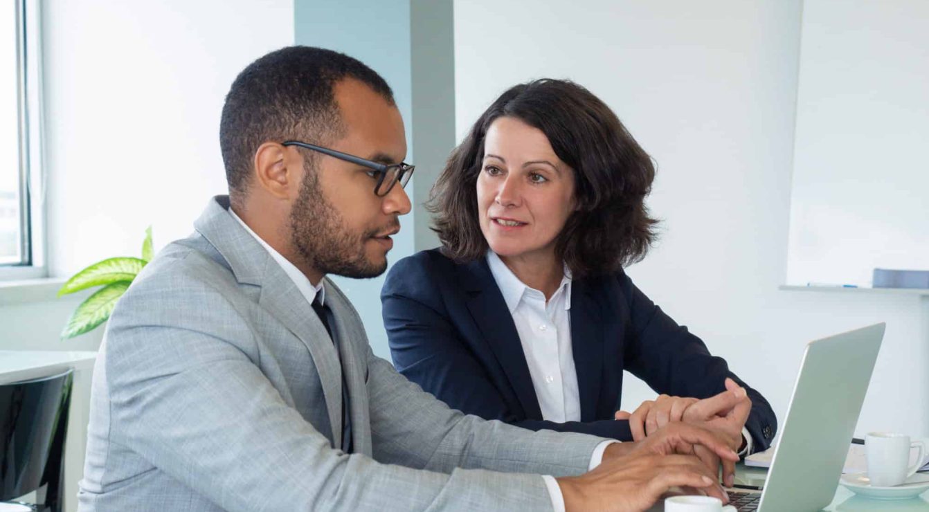 Two professionals engaged in a mentoring session in a nonprofit setting.