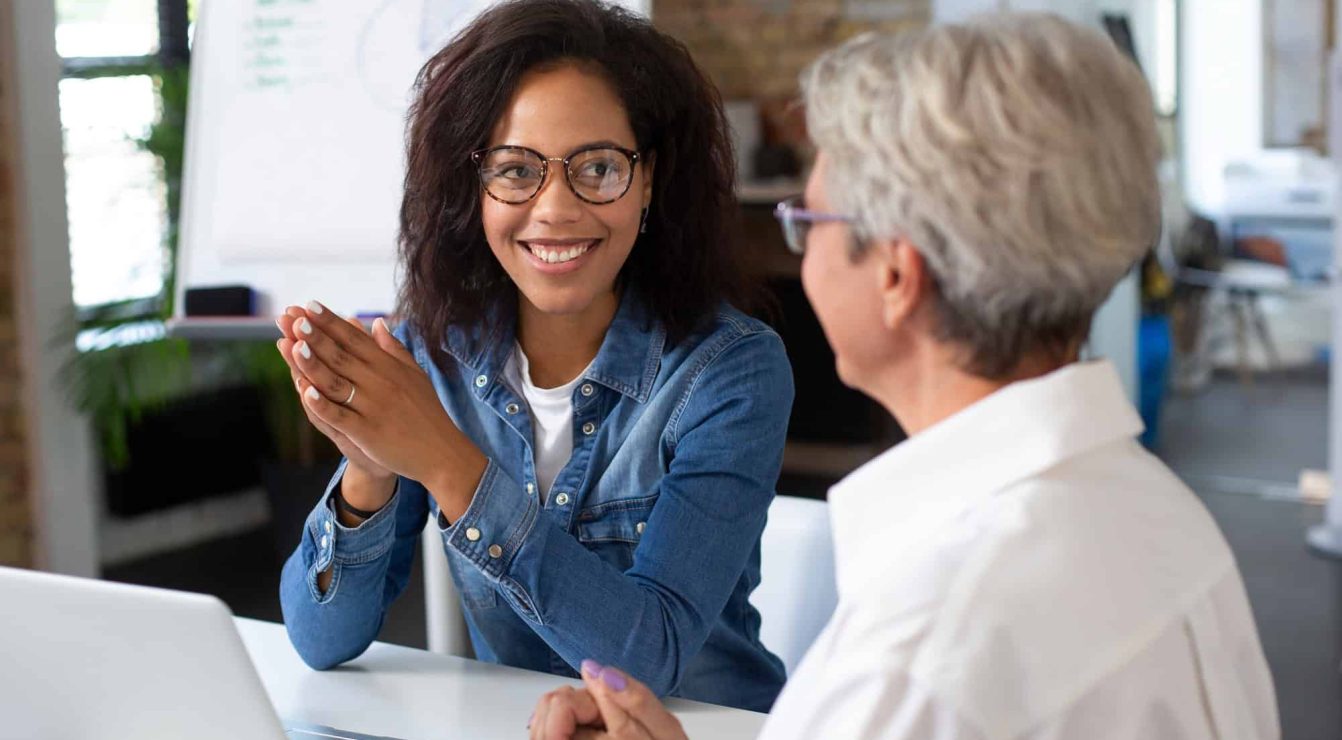 Two professionals engaging in a competency-based talent discussion in an office setting.