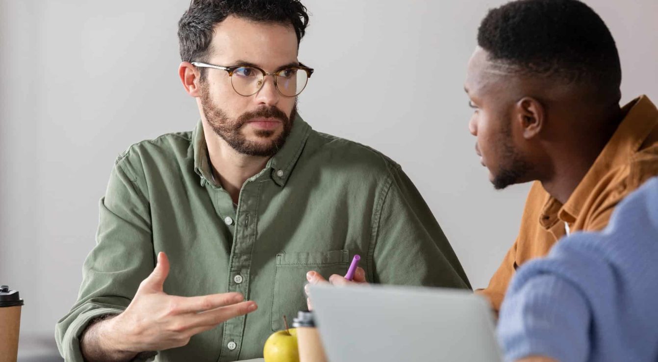 Two men engaged in a mentoring session, discussing educational strategies.